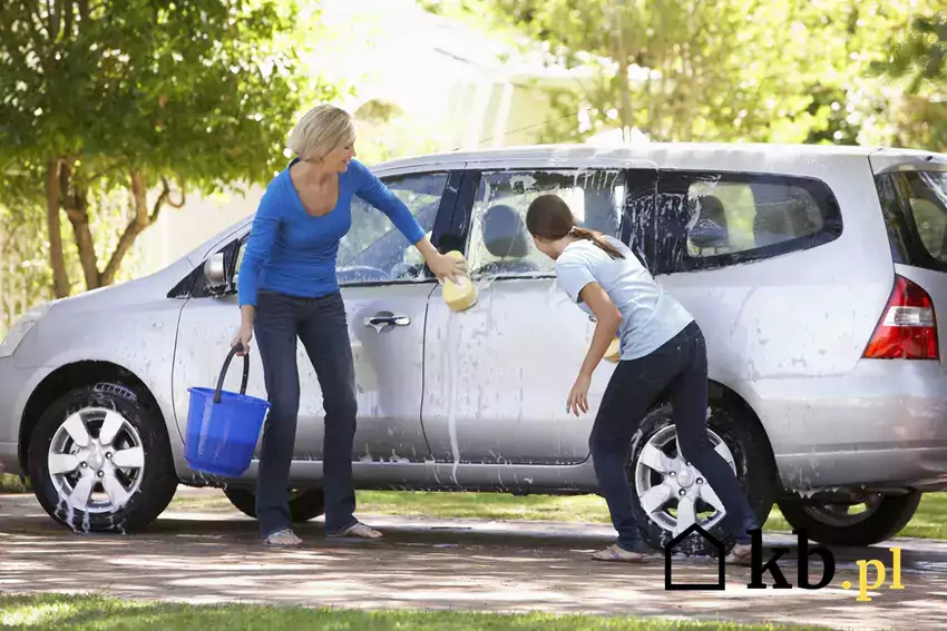 Rodzina myjąca auto na podwórku