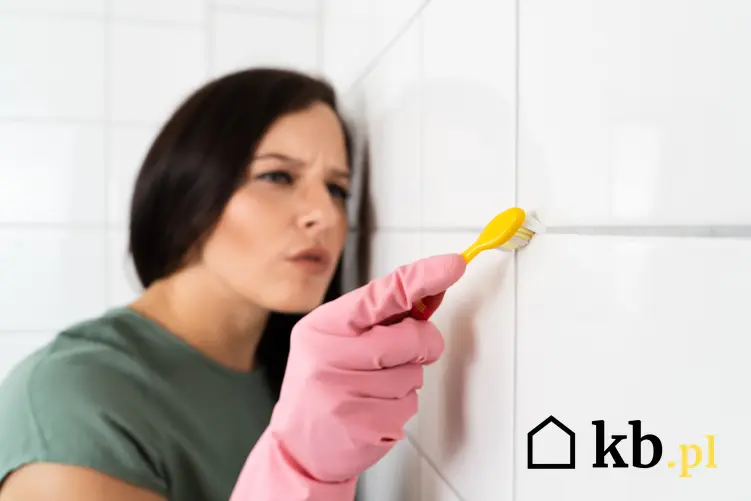 Kobieta podczas czyszczenia fug szczoteczką do zębów oraz domowe sposoby na czyszczenie fug