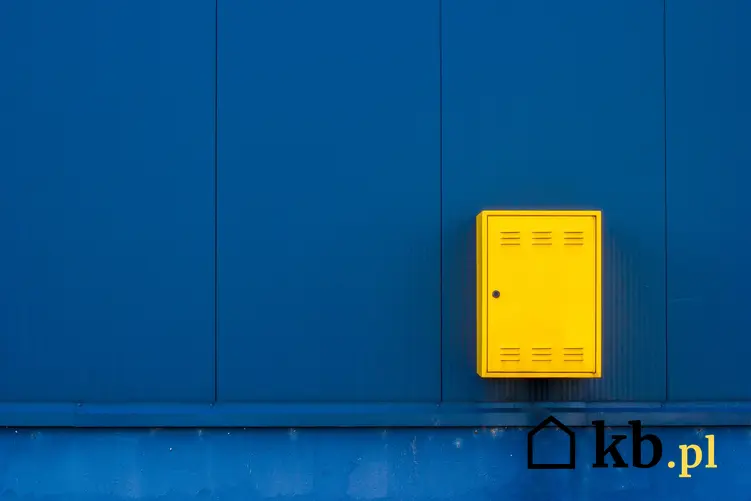 Żółta skrzynka gazowa na niebieskiej ścianie, a także szafki gazowe i ich rodzaje