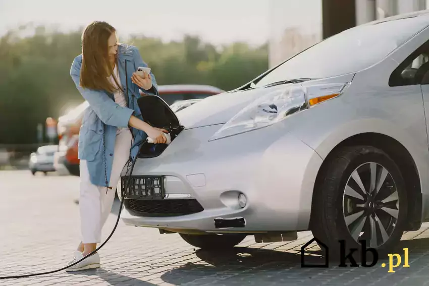 Ładowanie samochodu elektrycznego przez kobietę
