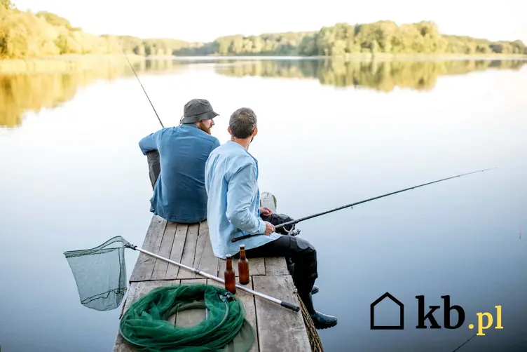 Para mężczyzn siedzi na pomoście łowiąc ryby, wspólne wędkowanie, co grozi za łowienie ryb bez karty wędkarskiej