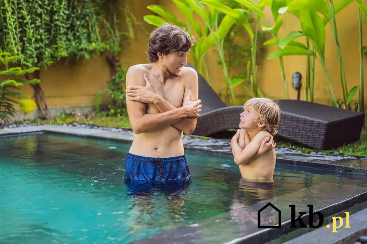 Mężczyzna i chłopiec stoją zmarznięci w basenie ogrodowym, jacy są producenci podgrzewaczy do basenów ogrodowych