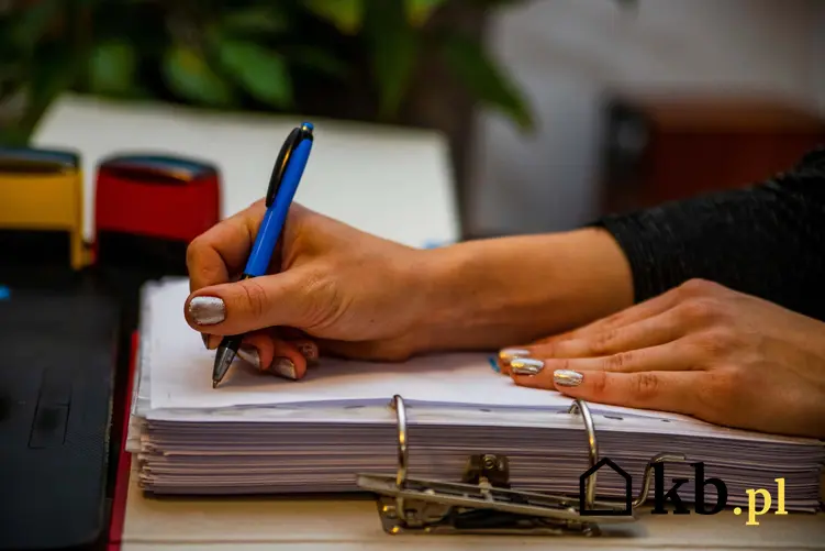 Kobieta podpisująca dokumenty, dłonie kobiety trzymające długopis, kobieta wypełniająca dokumenty z segreagtora, stosunek pracy a koszty uzyskania przychodu, jak obliczyć koszty uzyskania przychodu przy umowie o pracę