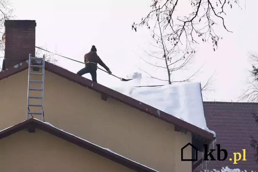 Odśnieżanie dachu przez mężczyznę