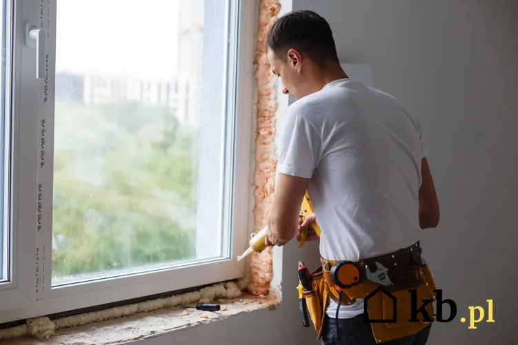 Mężczyzna przy montażu okien, a także cennik obróbki okien i ile kosztuje osadzenie okien krok po kroku