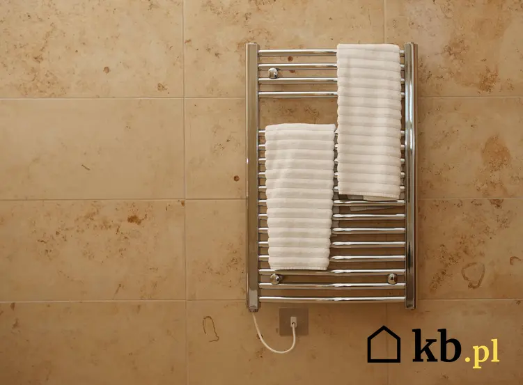 Grzejnik elektryczny na ścianie w łazience z ręcznikiem, a także jaki grzejnik elektryczny do łazienki wybrać