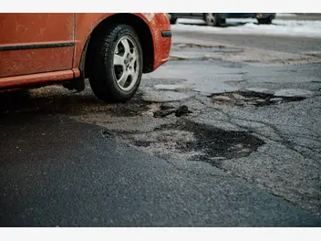 Ilustracja artykułu kto ponosi odpowiedzialność za uszkodzenie auta po wjechaniu w dziurę w drodze?