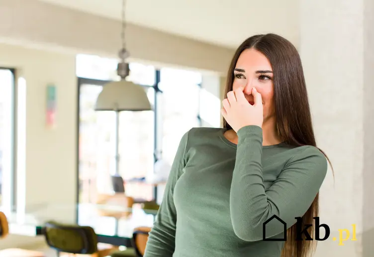 Kobieta w domu zatykająca sobie nos, a także najlepsze porady, jak zlikwidować zapach szamba w domu krok po kroku