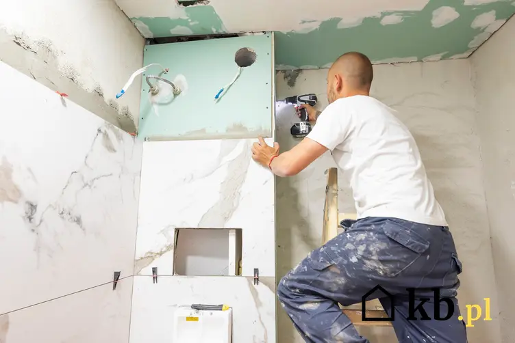 Mężczyzna podczas remontu łazienki, a także ile kosztuje generalny remont łazienki w bloku
