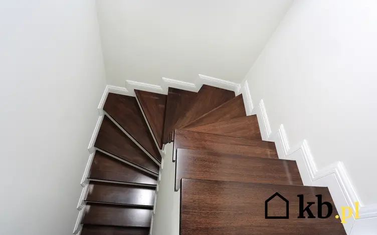 Ciemne kręte schody drewniane w domu, a także ceny schodów drewnianych w domu
