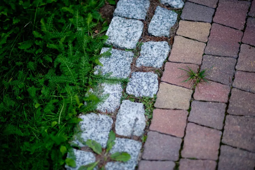 Przed układaniem kostki brukowej po budowie konieczne jest wyrównanie i odpowiednie zagęszczenie gruntu Kostka brukowa w ogrodzie
