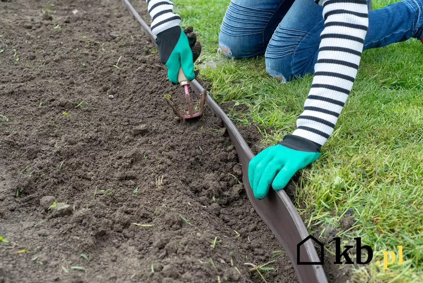Kobieta układająca obrzeża trawnikowe w ogrodzie