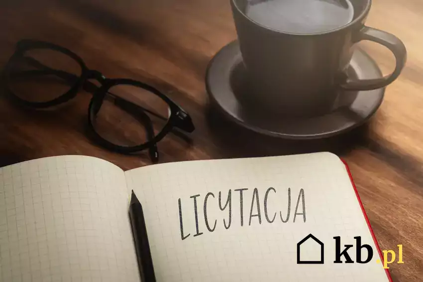 zeszyt z napisem licytacja, okulary, kawa