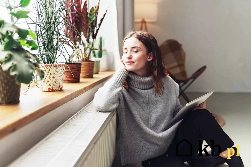 Kobieta siedząca przy kaloryferze