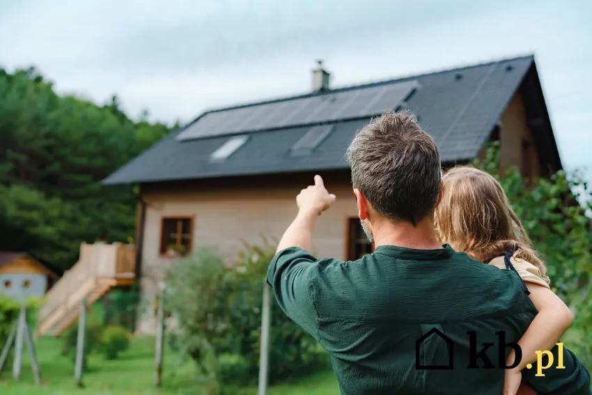 Mężczyzna z dzieckiem przy instalacji fotowoltaicznej