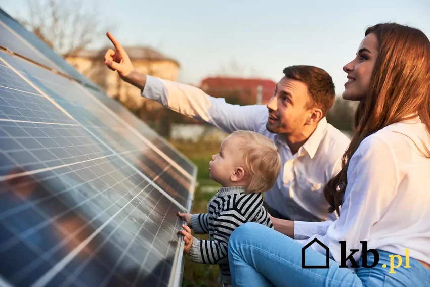 Przechowywana energia pozwala na większą niezależność energetyczną i obniżenie rachunków za prąd. Rodzina przy panelach fotowoltaicznych