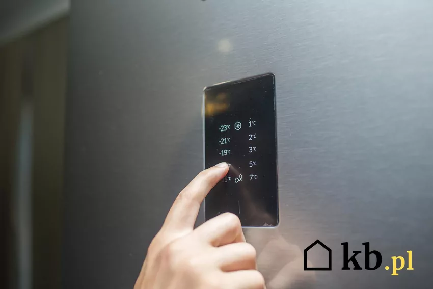 Wiele nowoczesnych modeli lodówek jest wyposażonych w specjalne strefy, umożliwiające dostosowanie warunków przechowywania do potrzeb konkretnych produktów Męska dłoń i panel z temperaturami na lodówce