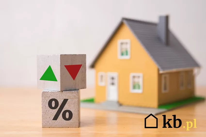 Spadek wartości nieruchomości może osiągnąć poziom nawet 30% Makieta domu i kostki ze strzełkami