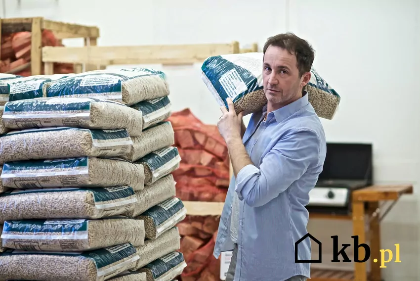 Pellet workowany sprzedawany jest w oznakowanych opakowaniach Mężczyzna trzyma pellet workowany