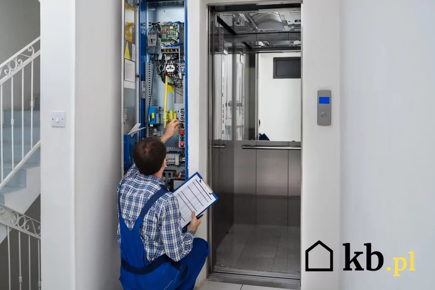 mężczyzna naprawia windę w bloku