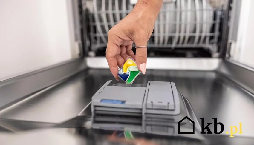 Te tabletki do zmywarki dobrze sobie radzą z zabrudzeniami Kobieta wkłada tabletkę do zmywarki