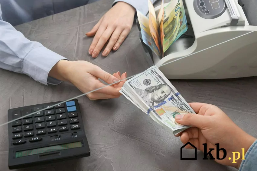Dłoń wyciągająca banknoty w stronę kasy sklepowej