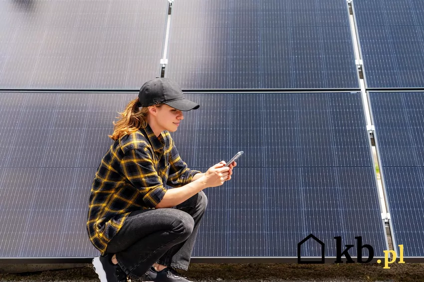 Sztuczna inteligencja uczy się schematu dnia użytkownika, okresów zwiększonego zużycia energii, przewiduje problemy i optymalizuje pracę falownika Kobieta z telefonem przy panelach fotowoltaicznych