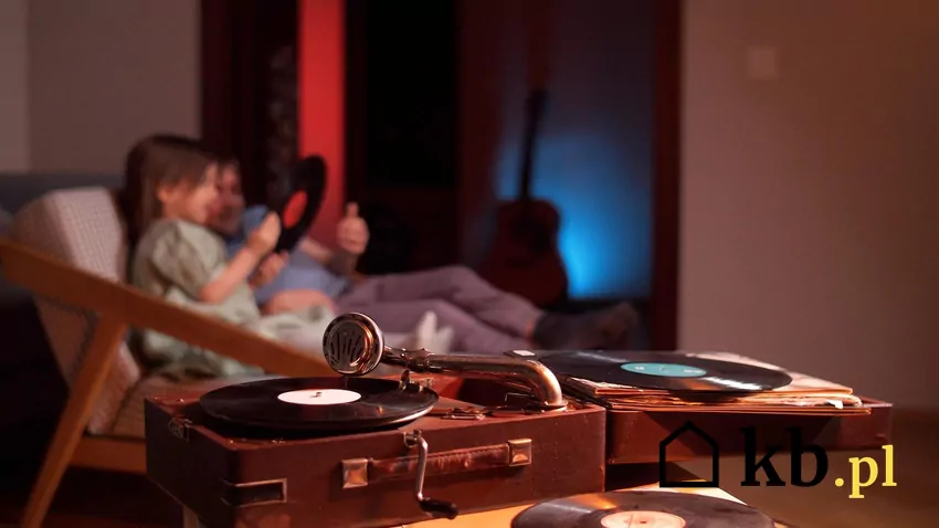 Gramofon Bambino to jeden z najbardziej rozpoznawalnych polskich gramofonów, szczególnie ceniony za przenośną, walizkową konstrukcję i istotną rolę w kulturze Vintage winyl a w tle ludzie na kanapie