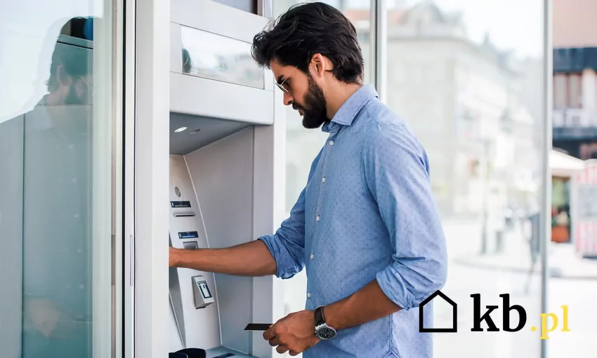 mężczyzna wpłaca pieniądze we wpłatomacie