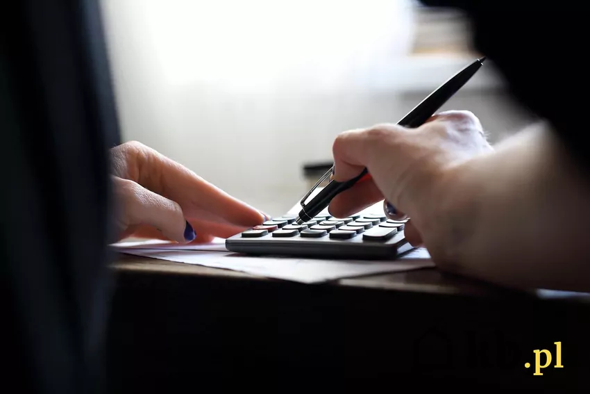 Świadome zarządzanie pieniędzmi i oszczędzanie to klucz do bezpieczeństwa finansowego – nawet przy wysokich zarobkach. Planowanie wydatków pomaga unikać pułapki nadmiernej konsumpcji. kobieta liczy na kalkulatorze