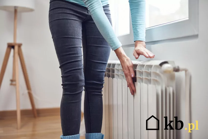 kobieta sprawdza temperaturę grzejnika