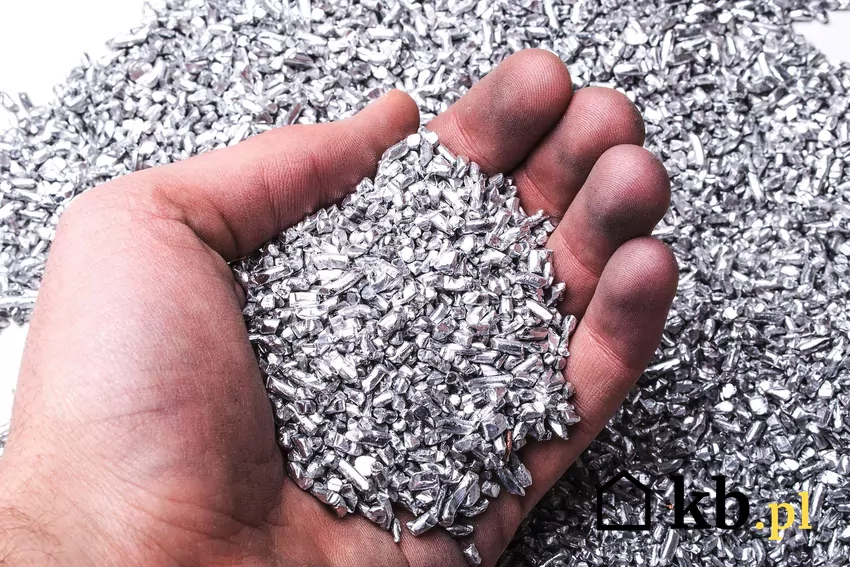 Dłoń trzymająca opiłki aluminium