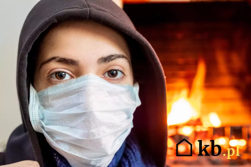 Kobieta w maseczce przy kominku