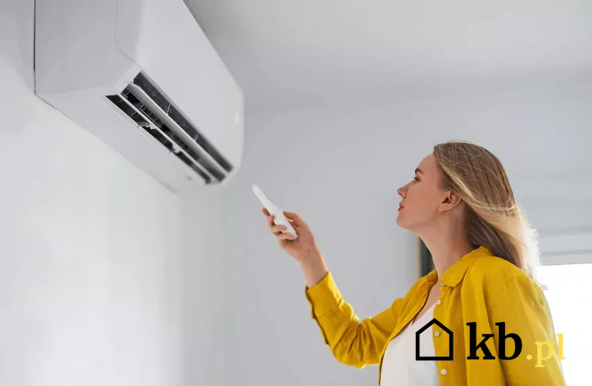 Kobieta uruchamia klimatyzator za pomocą pilota