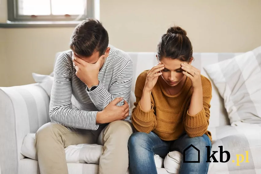 smutna kobieta i mężczyzna siedzą na kanapie w mieszkaniu