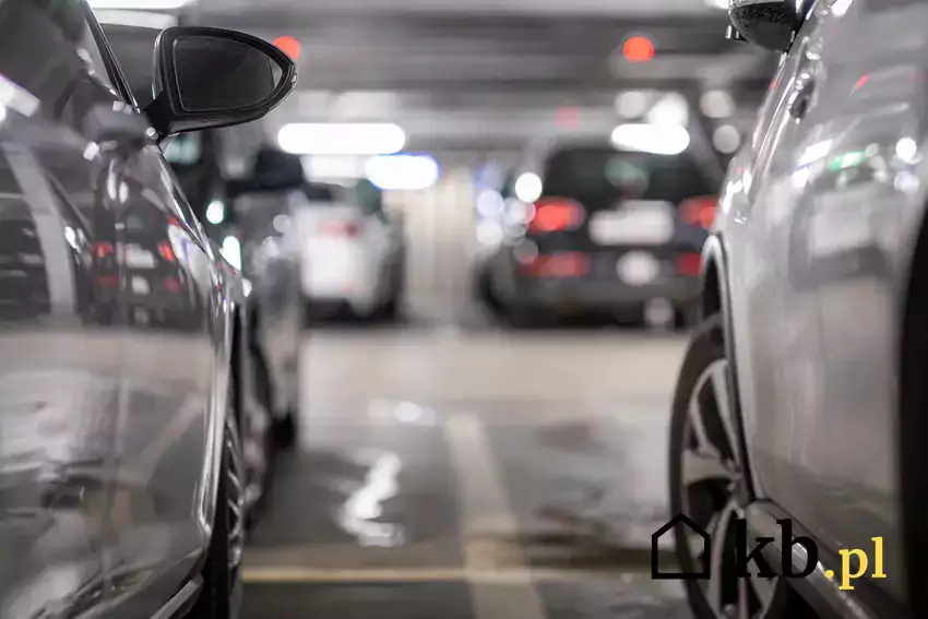 Zdjęcie przedstawiające zaparkowane obok siebie samochody stojące w garażu podziemnym.