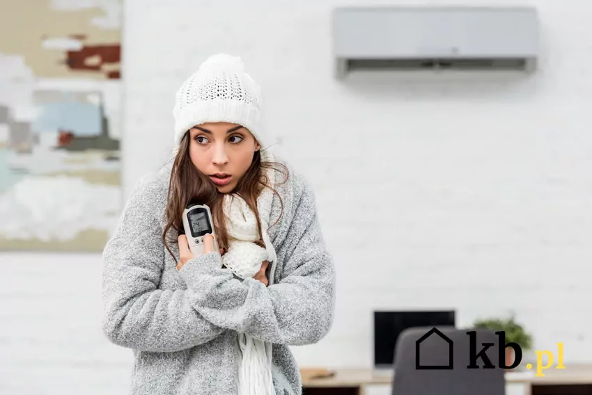 W okolicach −5°C efektywność klimatyzacji w trybie grzania zaczyna spadać wyraźnie, a poniżej tej wartości znaczna część urządzeń nie jest już w stanie utrzymać stabilnego grzania Kobieta w czapce przy klimatyzacji