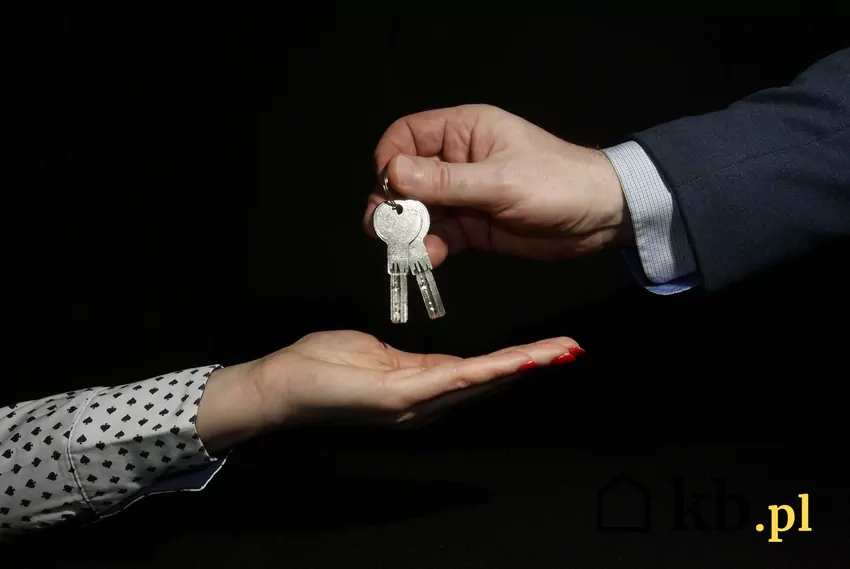 Dłonie przekazujące sobie klucze do mieszkania