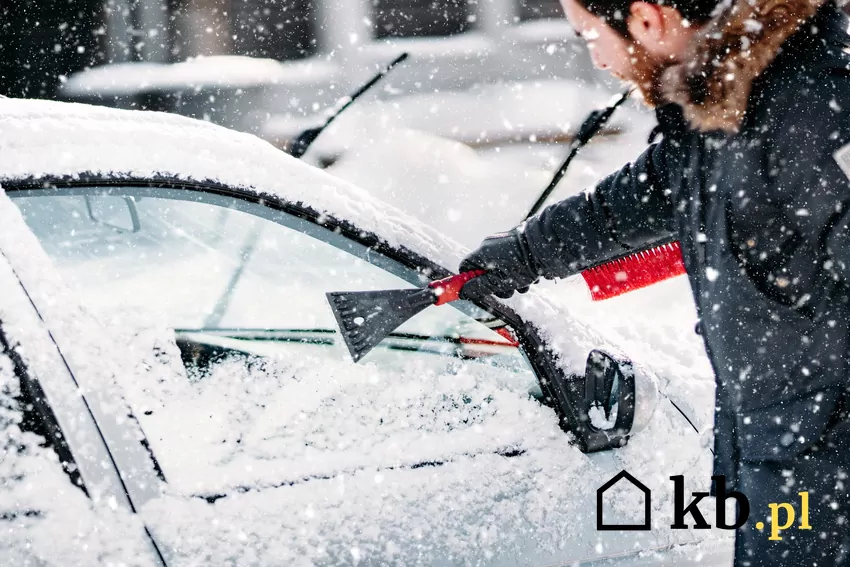 Dobra widoczność jest podstawą bezpiecznej jazdy mężczyzna odśnieża szybę samochodu