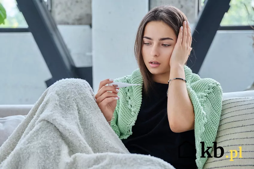 Chora kobieta spogląda na termometr