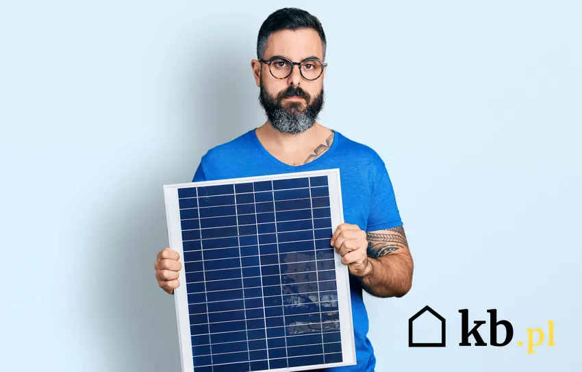 mężczyzna trzyma mały panel PV