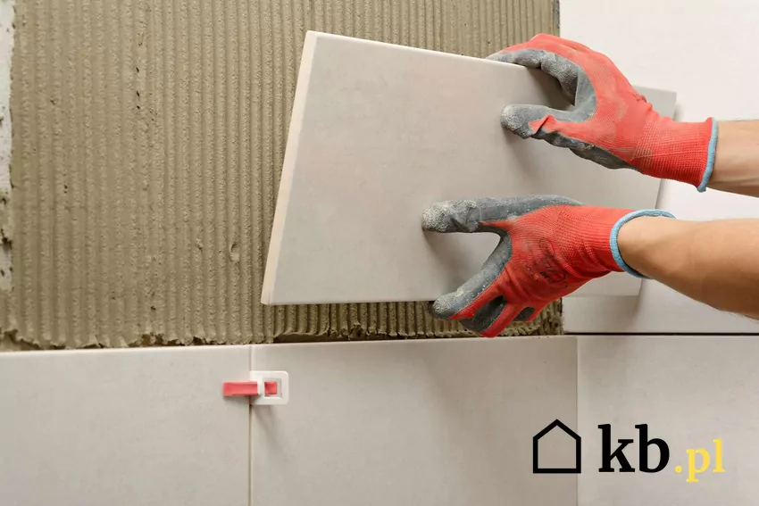 Fachowiec układa płytki na ścianie w łazience