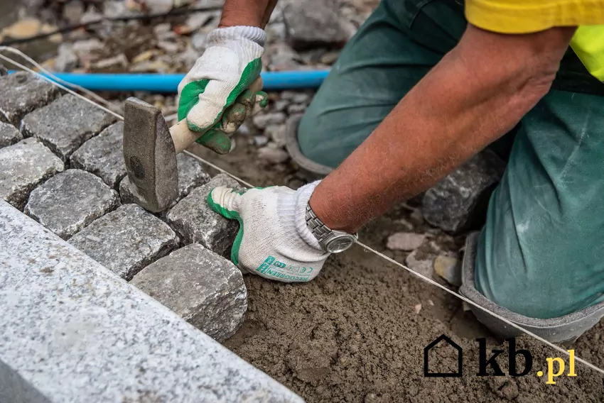 Budowa ścieżek i podjazdów to ważny wydatek Mężczyzna układa kostkę brukową na chodniku