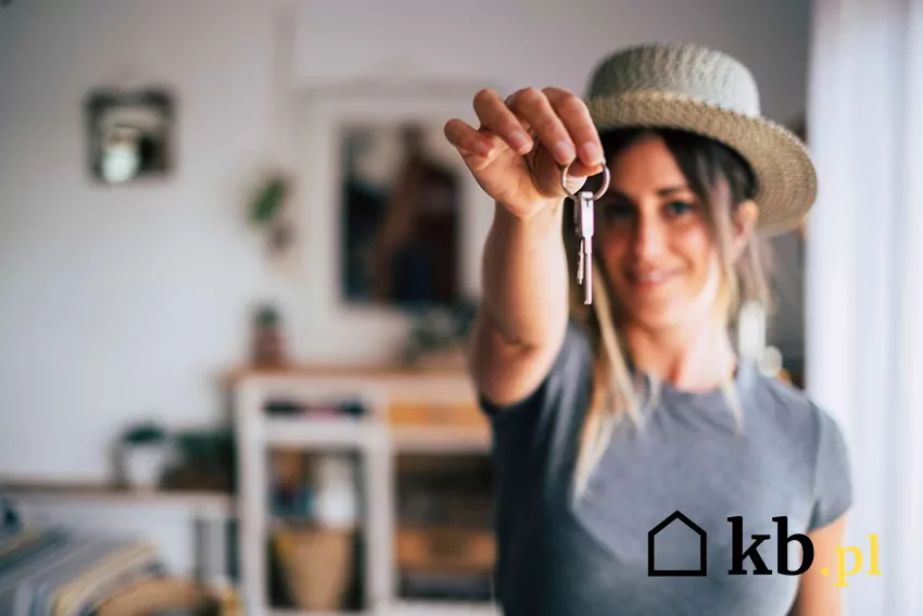 Kobieta trzyma klucz w wyciągniętej dłoni