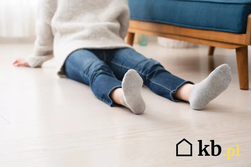 Nieodpowiednio użytkowana podłogówka jest narażona na poważne awarie człowiek siedzi na ciepłej podłodze