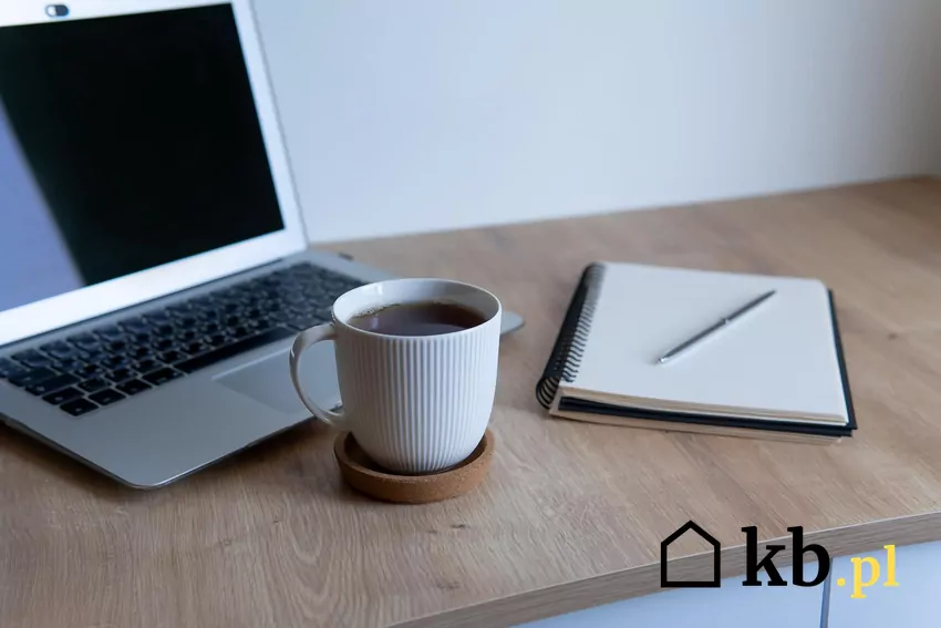 Kawa zaparzona w kubku obok laptopa