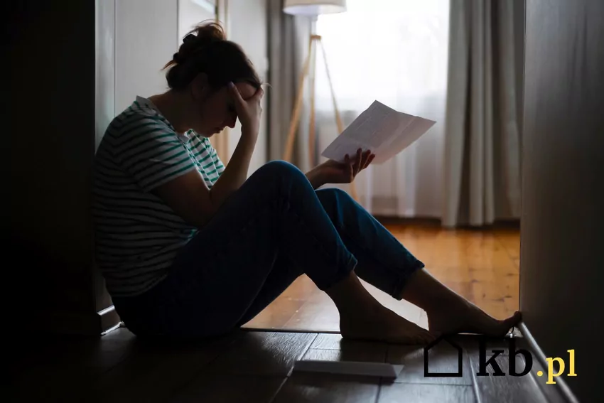 smutna kobieta trzyma nakaz eksmisji