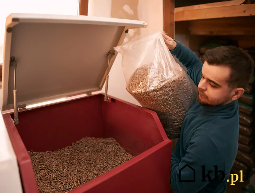 mężczyzna dorzuca pellet do podajnika