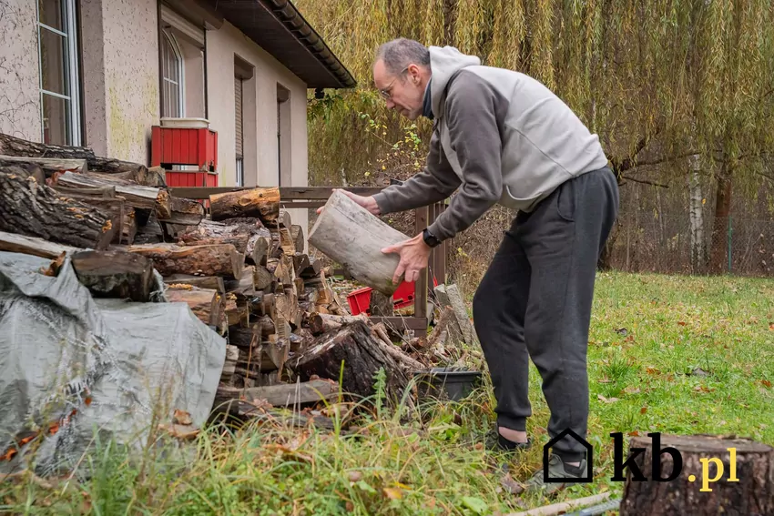 Mężczyzna układa drewno
