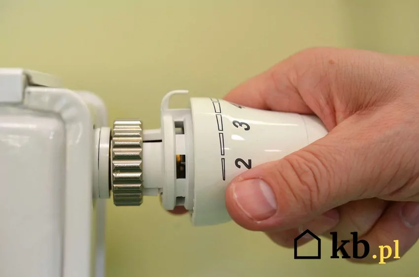 Dłoń na pokrętle grzejnika